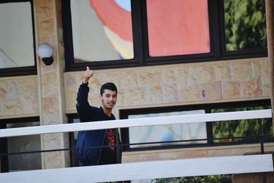 Portrait of smiling young man showing thumbs up