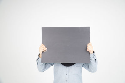 Close-up of man holding camera over white background