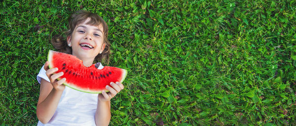 Portrait of young woman standing against plants