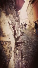 People walking in alley amidst buildings