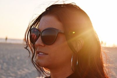 Close-up of woman in sunglasses against sky at beach