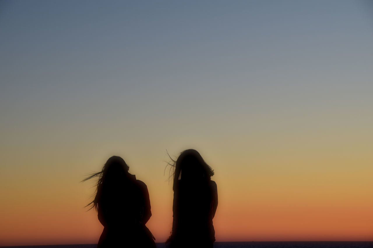 SILHOUETTE WOMAN STANDING AGAINST ORANGE SKY DURING SUNSET