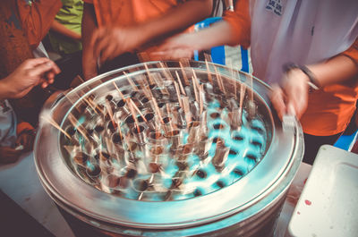 Midsection of people having ice cream in market