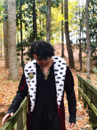 Front view of young man standing in forest