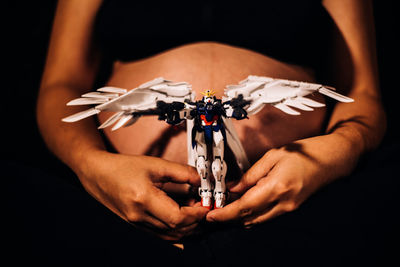 Midsection of pregnant woman holding toy