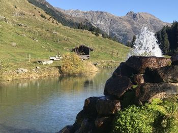 Scenic view of lake by mountain against sky