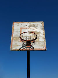 Low angle view of basketball hoop against clear blue sky