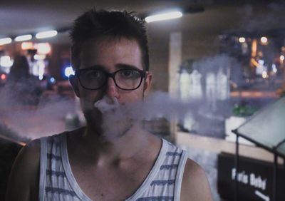 Portrait of young man emitting smoke