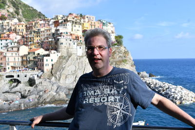 Portrait of man standing by sea against sky