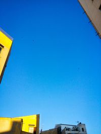 Low angle view of bird flying against blue sky