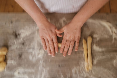 Cropped image of hand making breads on table