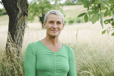 Portrait of young woman standing against plants