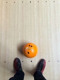 Close-up of ball with human legs in bowling alley