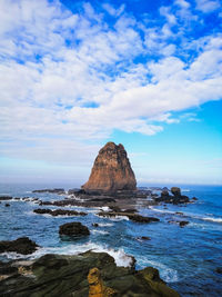 Rock formation in sea against sky