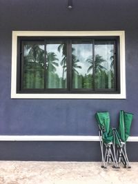 The folding bed is placed on the wall of the house, in a mirror with the shadow of a coconut tree.