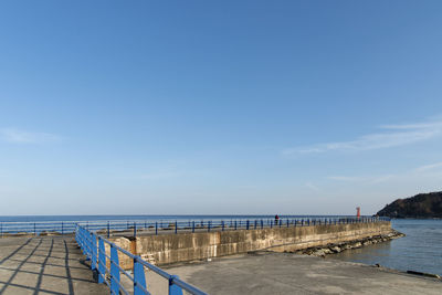 Pier over sea against blue sky