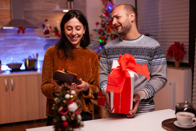 Portrait of smiling woman holding christmas tree