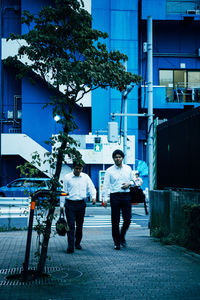 Rear view of people walking on road