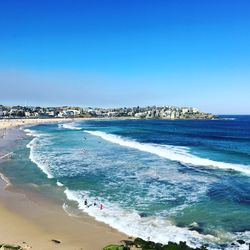 Scenic view of beach against clear blue sky