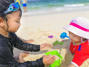 Sisters playing on sand at beach