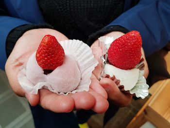 Midsection of woman holding desserts on hand 