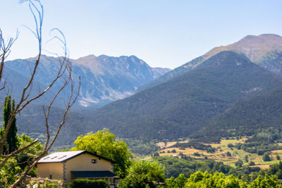 Scenic view of townscape by mountains against sky