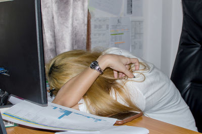 Woman napping on desk in office