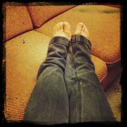 Low section of woman relaxing on tiled floor