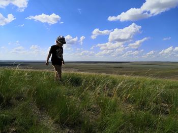 Man standing on field against sky