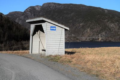 Built structure on mountain by lake against sky