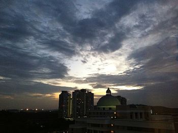 Buildings in city against cloudy sky