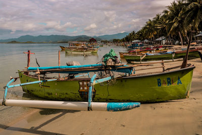Boats moored on beach against sky