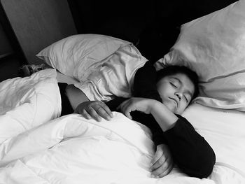 High angle view of boy sleeping on bed at home