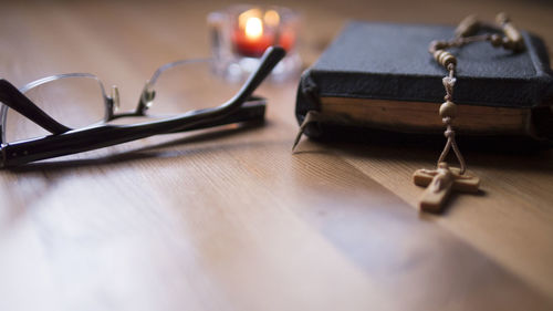 Close-up of eyeglasses and bible on table