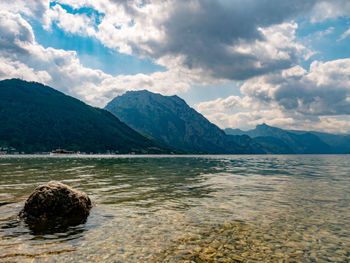 Scenic view of lake by mountains against sky