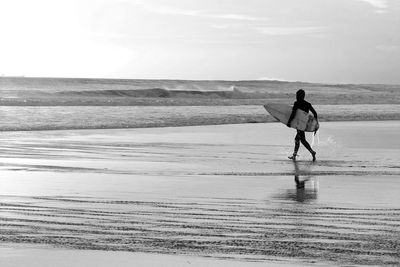 Silhouette surfer walking on the beach