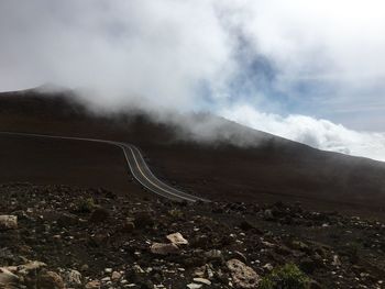 Empty road by mountain against sky