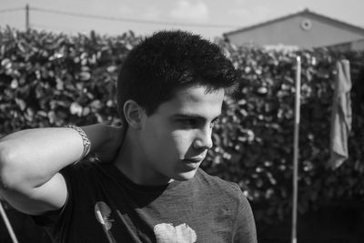 Close-up of teenage boy standing in back yard on sunny day