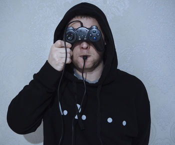 Portrait of man wearing sunglasses standing against wall