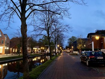 Street amidst buildings against sky at dusk