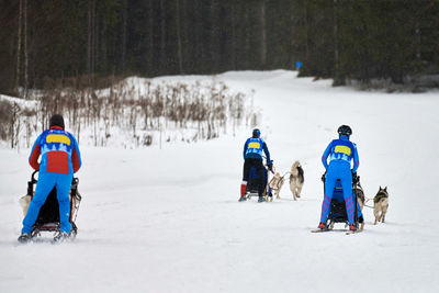 Rear view of people skiing on snowcapped field