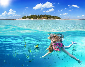 Man swimming in sea against sky