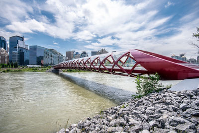 Bridge over river in city against sky