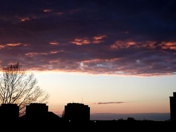 Silhouette of building against cloudy sky
