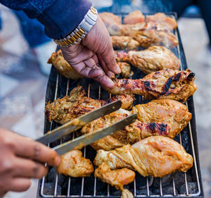 Midsection of person preparing food on barbecue grill
