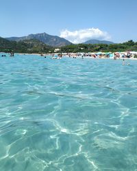 People enjoying in sea against sky
