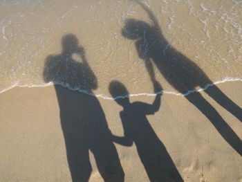 Shadow of family on sand at beach