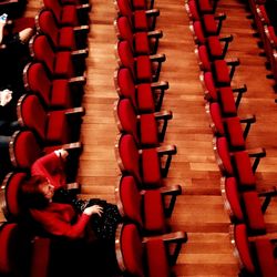 Full length of man with red chairs in stadium