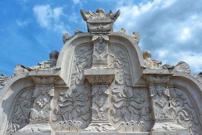 Low angle view of statue of building against cloudy sky