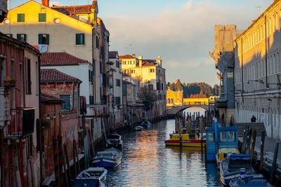 Boats in canal amidst buildings in city